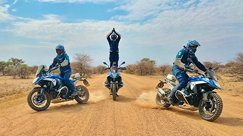 Hindistan erkek takımının düzen içerisinde sürüş halinde görünümü, ortadaki sürücü motosikletinin üzerinde neredeyse dik dururken ellerini başının üzerinde birleştirmiş halde.