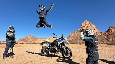 İtalyan erkek takımı fotoğraf etabını gerçekleştiriyor. Bir sürücü R 1300 GS motosikletinden yükseğe sıçrıyor.